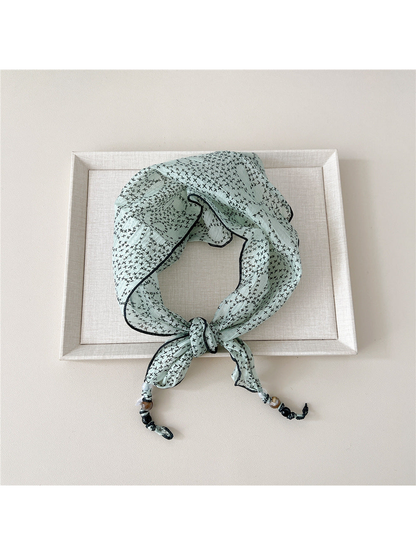 Mint Cross triangular scarf tied with beaded tips