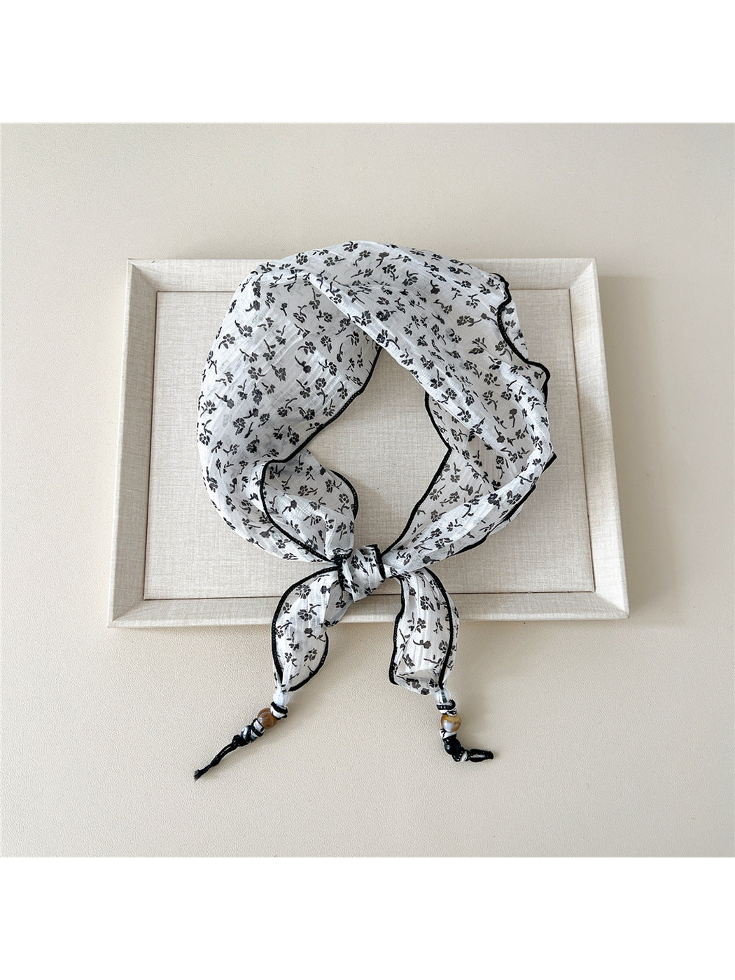White Sprigs triangular scarf tied with beaded tips