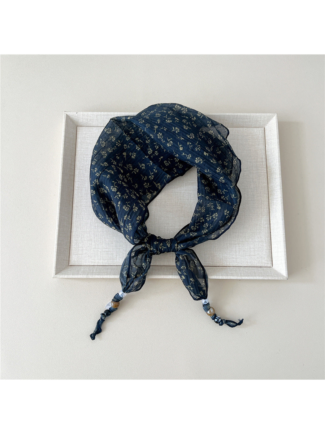 Navy Sprigs triangular scarf tied with beaded tips