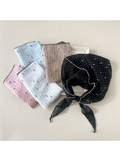 Black patterned triangle scarf tied beside folded color options