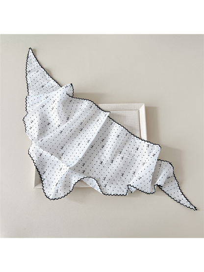 White triangle scarf opened to show its polka-dot and bow pattern