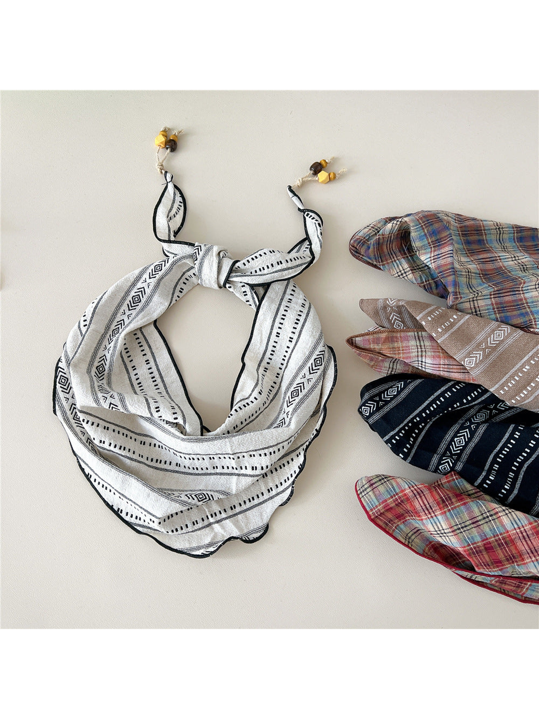 Off White geometric scarf beside folded color styles