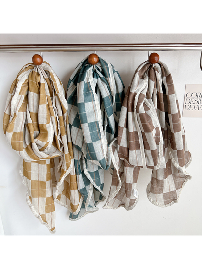 Yellow, turquoise and dark brown plaid scarves hanging side by side