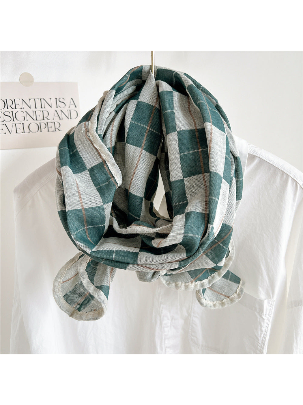 Turquoise plaid scarf draped over a white shirt