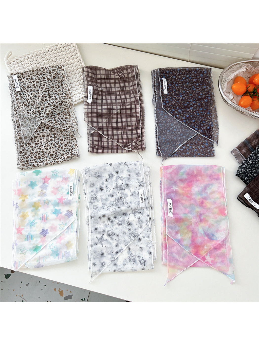 Multiple long narrow scarf styles displayed folded in a flat lay