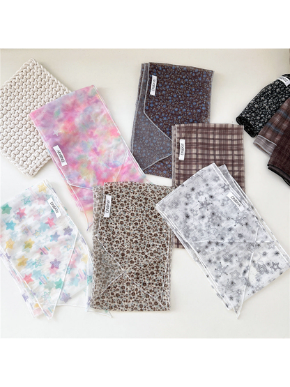 Multiple star, floral and plaid long narrow scarf styles displayed together