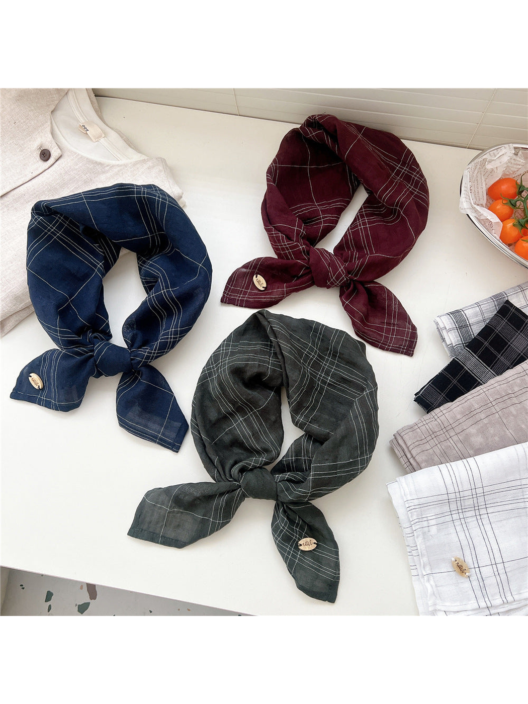 Navy, burgundy and dark green plaid scarves tied for display