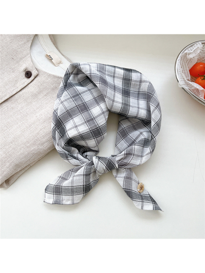 White and gray dense plaid scarf tied in a loop