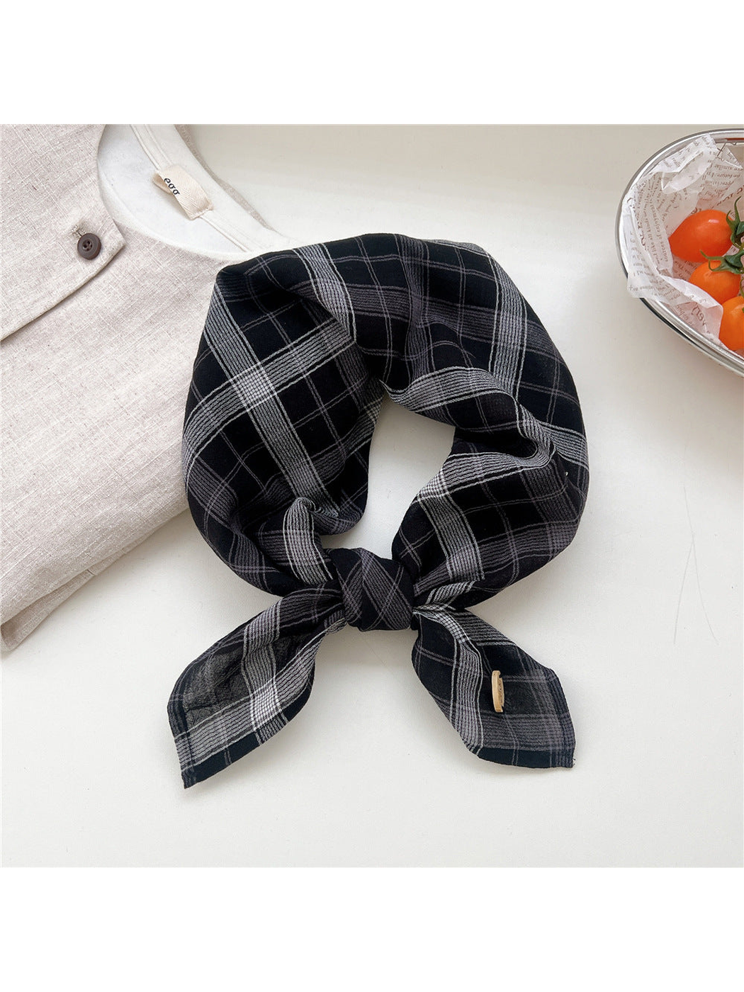 Black and gray dense plaid scarf tied in a loop