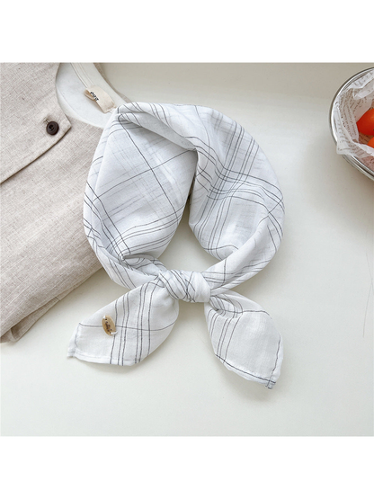 White fine-line plaid scarf tied in a loop
