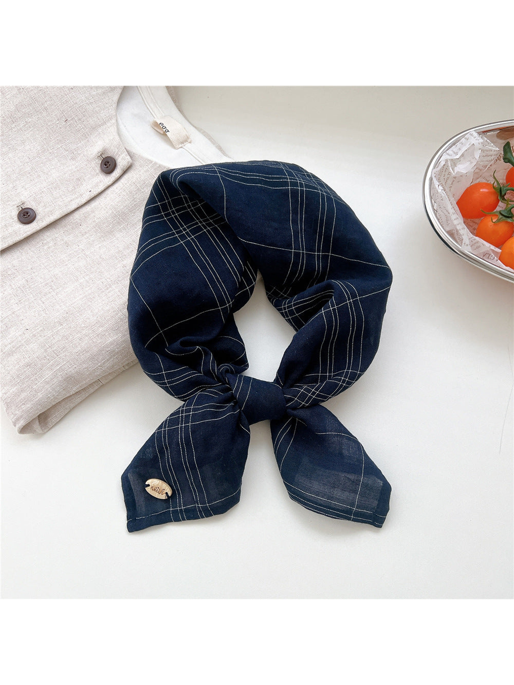Navy fine-line plaid scarf tied in a loop