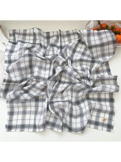 White and gray plaid scarf spread to show its stitched edges and drape