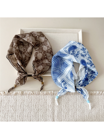 Brown paisley and blue peacock floral scarf-style headbands displayed together