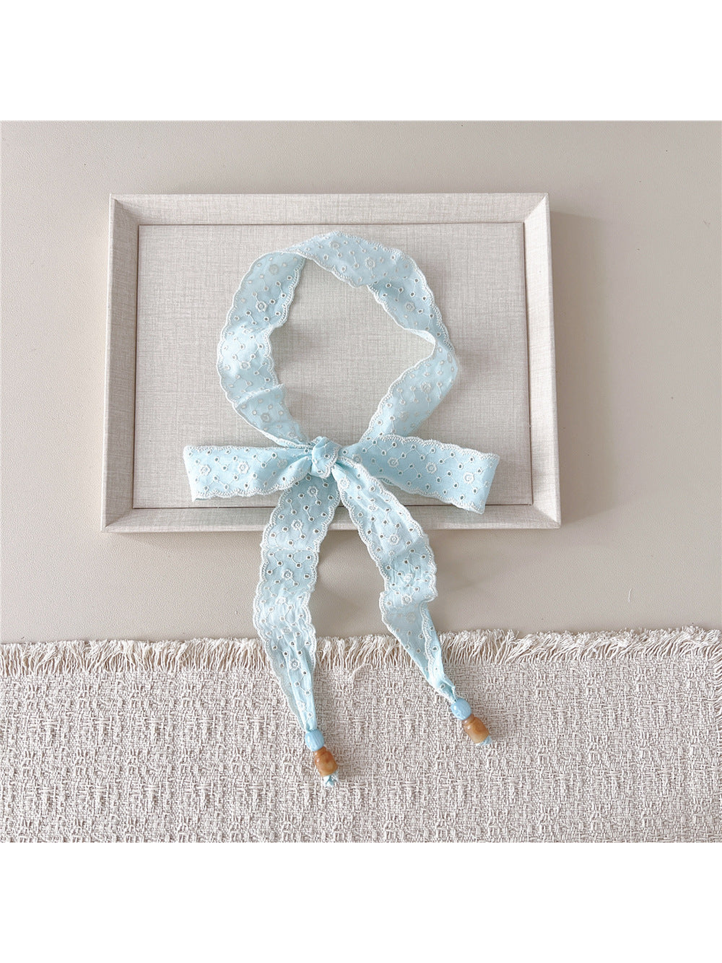 Light blue Eyelet Lattice skinny scarf tied in a bow with beaded ends