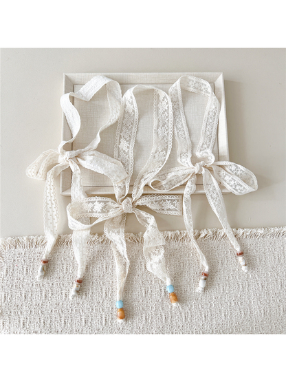 Three ivory embroidered skinny scarf styles tied in bows