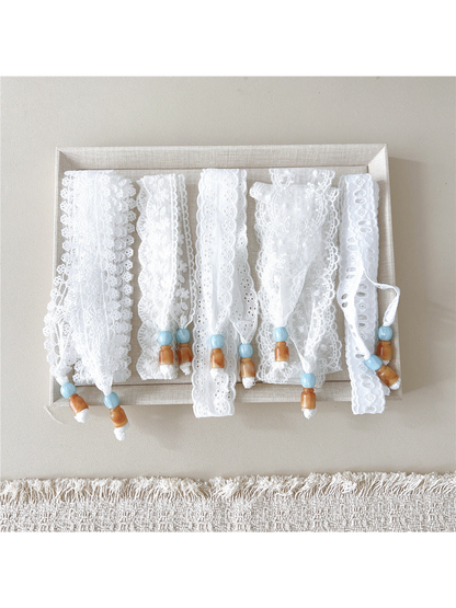 Five white eyelet and floral skinny scarf styles displayed flat