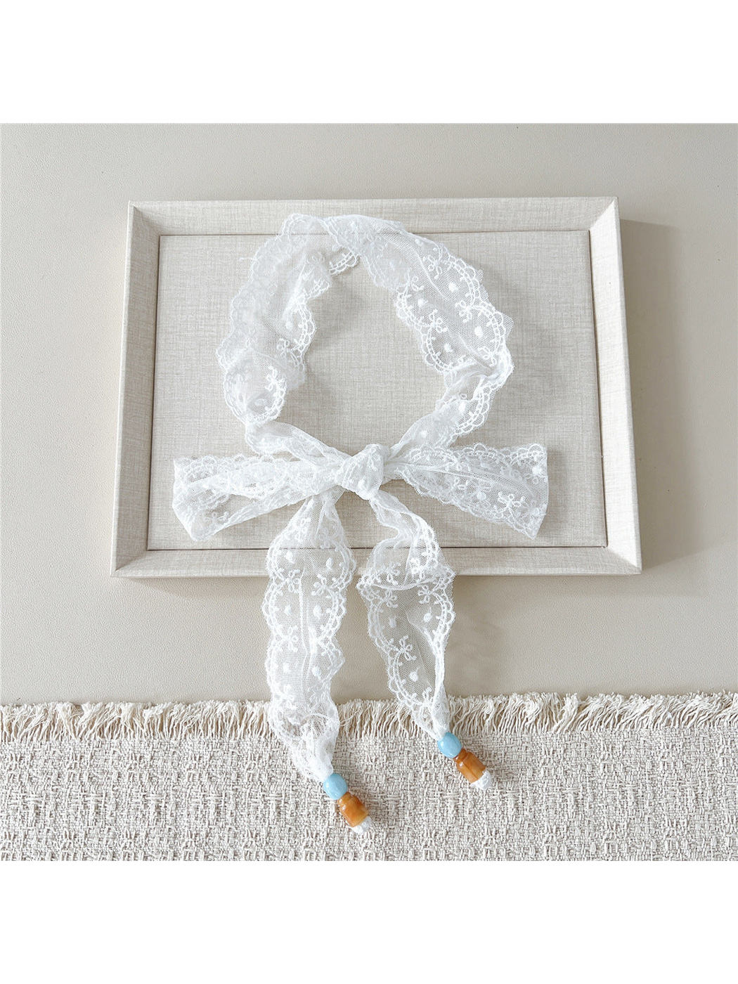 White Dotted Floral skinny scarf tied in a bow with beaded ends