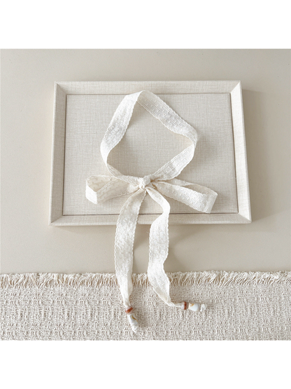 Ivory Striped Openwork skinny scarf tied in a bow with beaded ends
