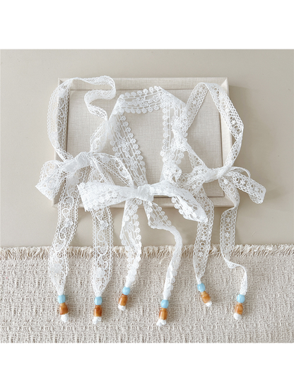 Three white openwork skinny scarf styles tied in bows