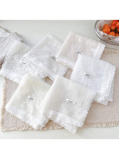 Six white lace scarf styles folded together on a neutral tabletop