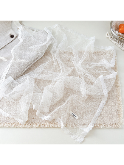 White lace scarf spread out to show the fine floral pattern and scalloped border