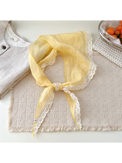 Yellow triangle scarf tied with cream openwork lace trim