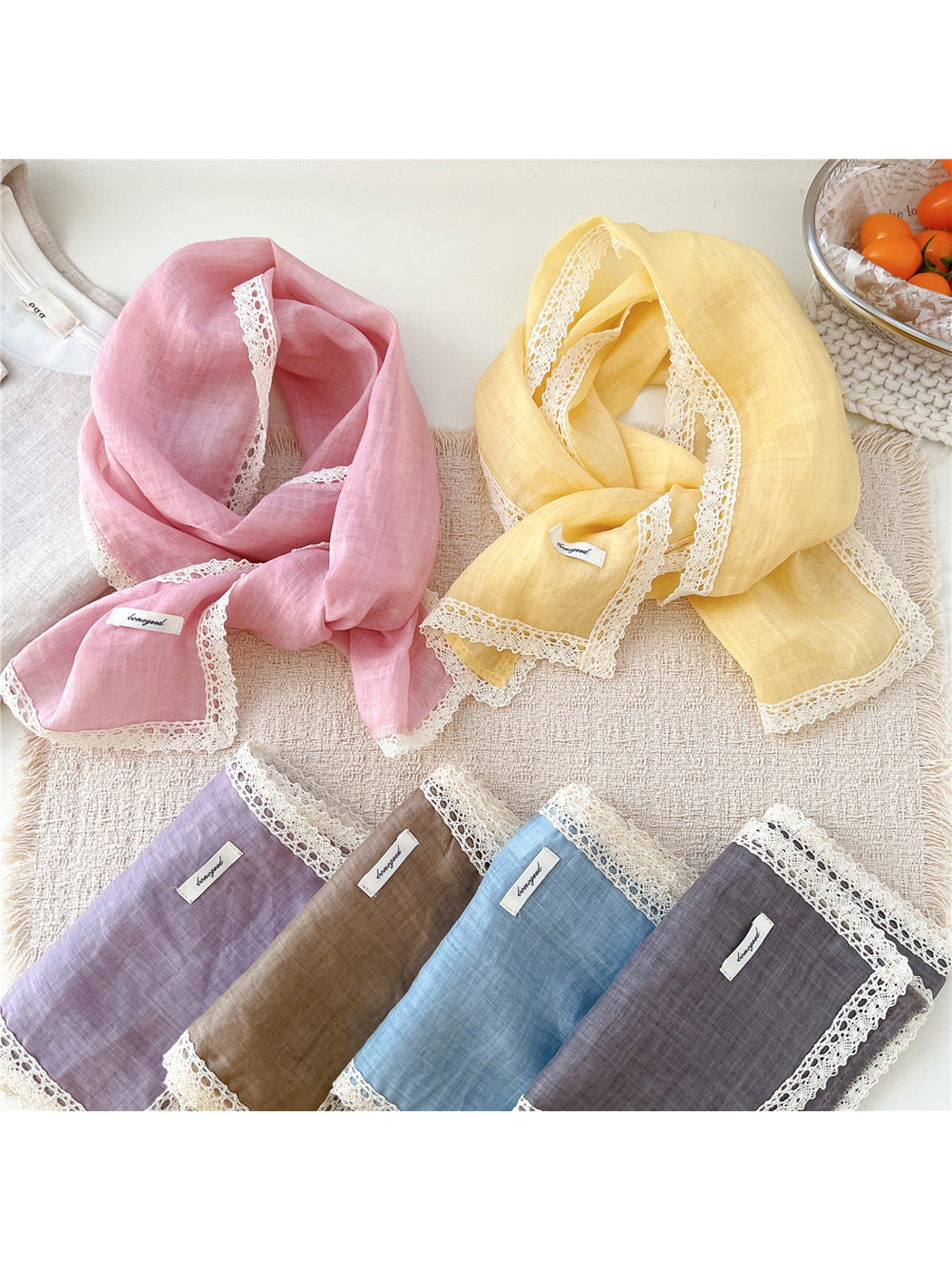 Pink, yellow, purple, green, blue and gray lace-trim scarves displayed together