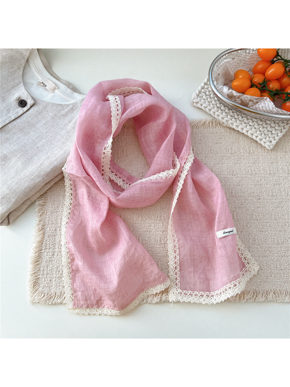 Pink scarf draped on a textured neutral surface