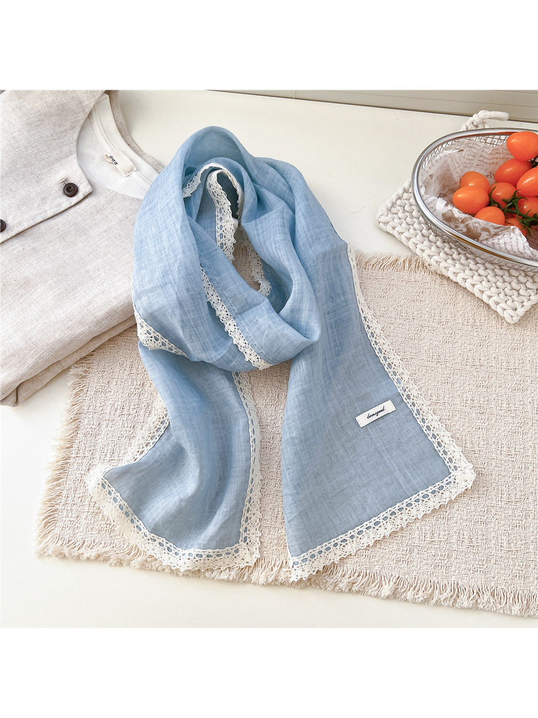 Blue scarf draped on a textured neutral surface
