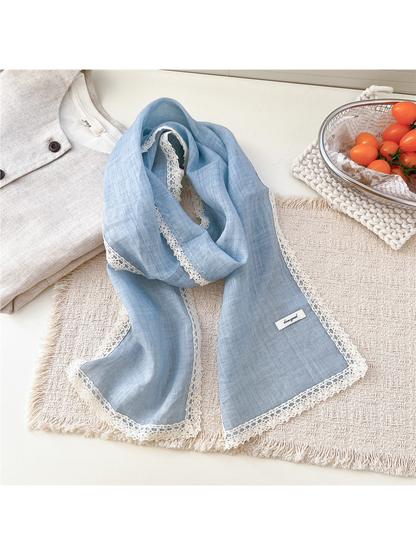 Blue scarf draped on a textured neutral surface