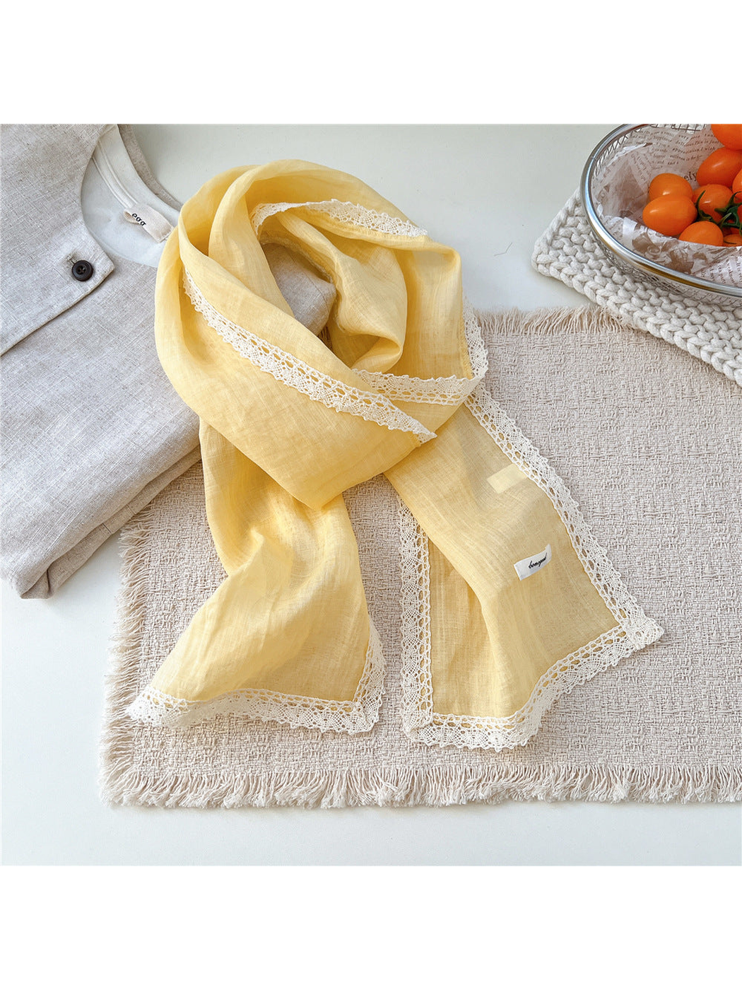 Yellow scarf draped on a textured neutral surface