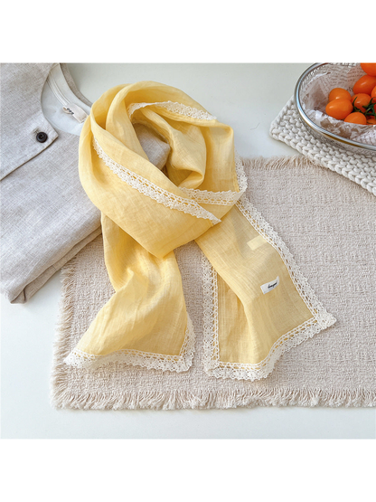 Yellow scarf draped on a textured neutral surface