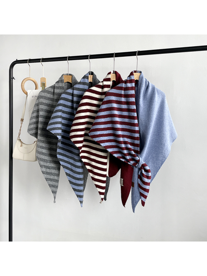 Multiple striped and solid color-block scarf styles displayed on a clothing rack