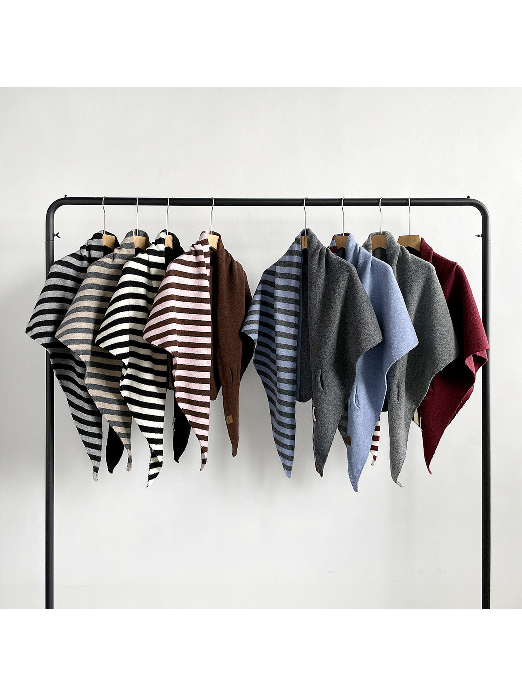 Assorted scarf styles arranged across a clothing rack