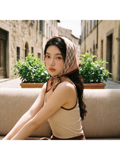 Brown and cream plaid scarf worn as a head scarf outdoors