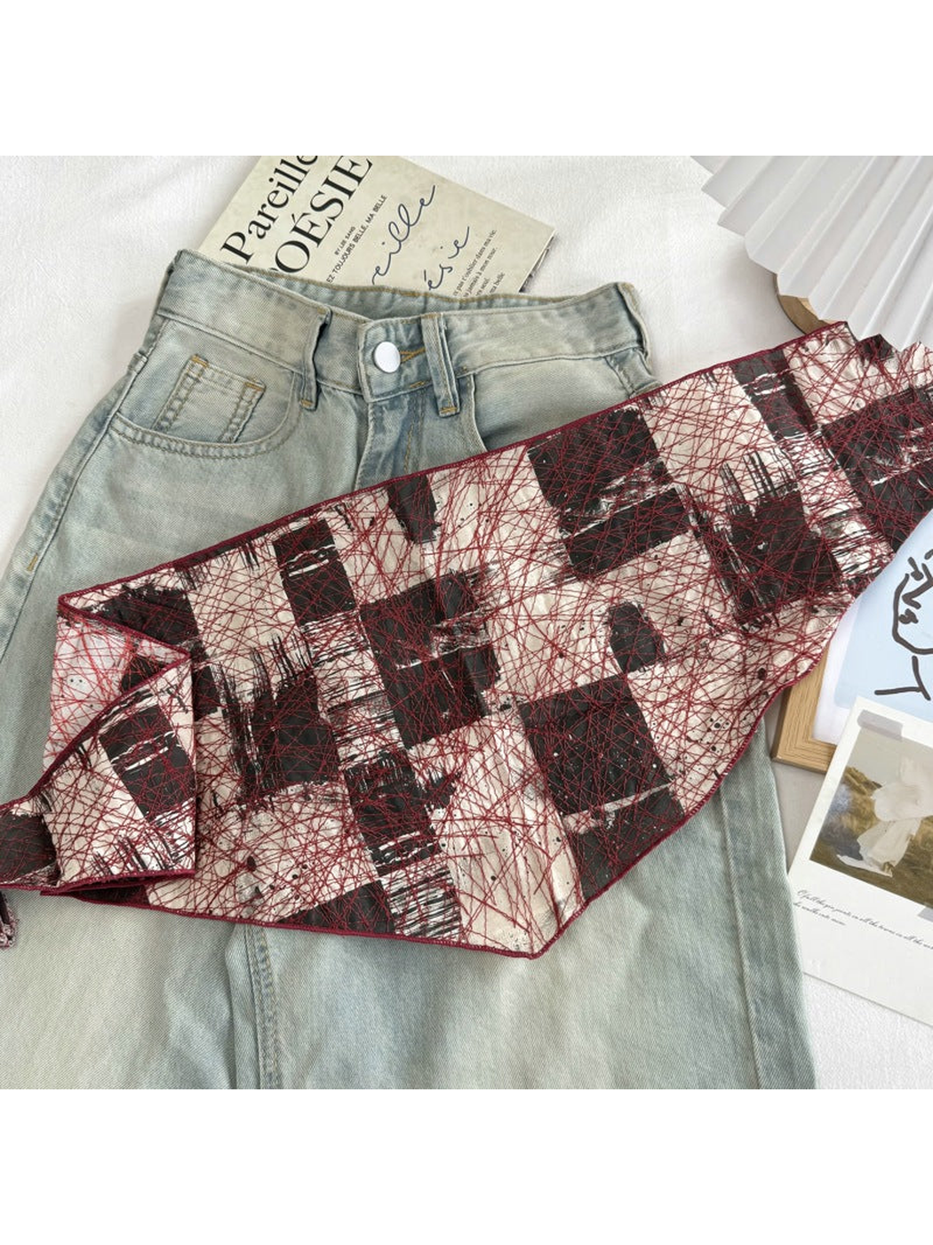 Red abstract mesh scarf extended to show its narrow shape and pointed ends