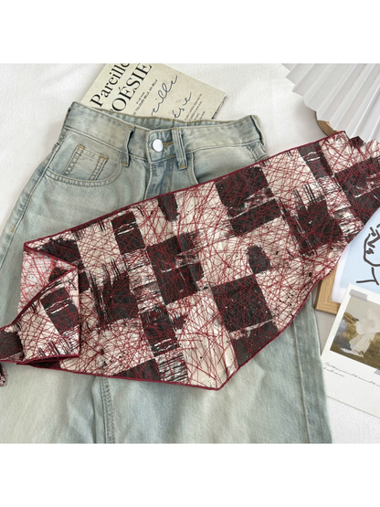 Red abstract mesh scarf extended to show its narrow shape and pointed ends