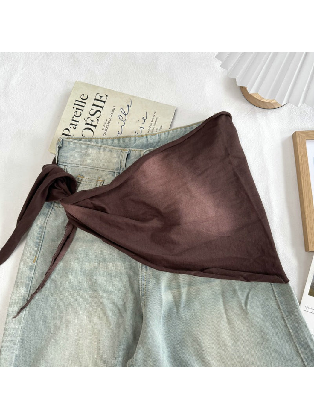 Brown tonal scarf styled over light-wash jeans