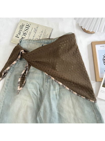 Coffee openwork scarf tied around light-wash jeans