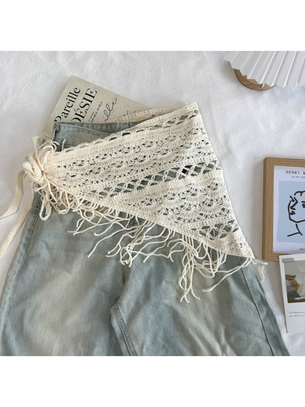 Ivory openwork triangle scarf styled over light-wash jeans