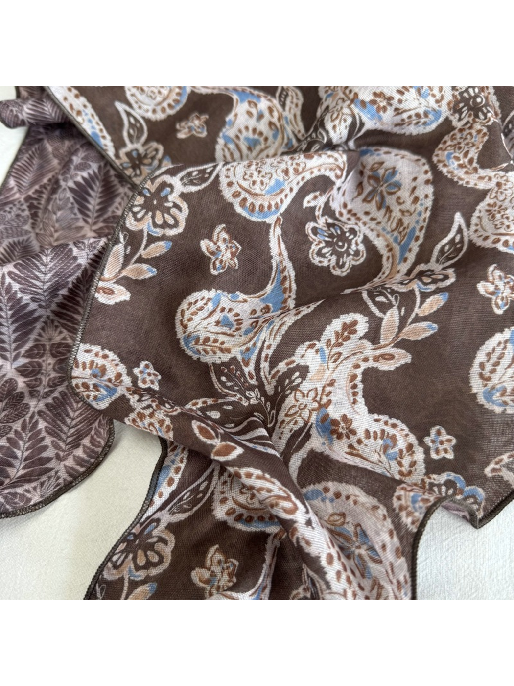Close-up of the Brown Paisley scarf print and stitched wavy edge