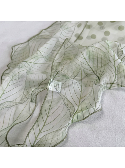 Close-up of the Green Leaves scarf with polka dots, outlined leaves and stitched edge