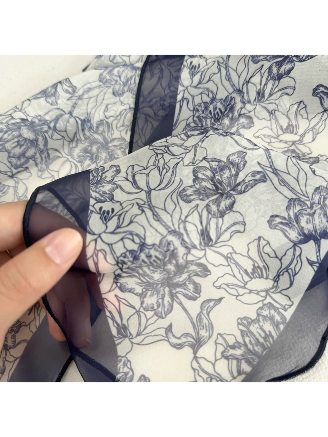 Close-up of the navy line-art floral print and sheer border