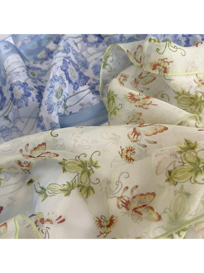 Close-up of blue floral and butterfly scarf prints with finished edges