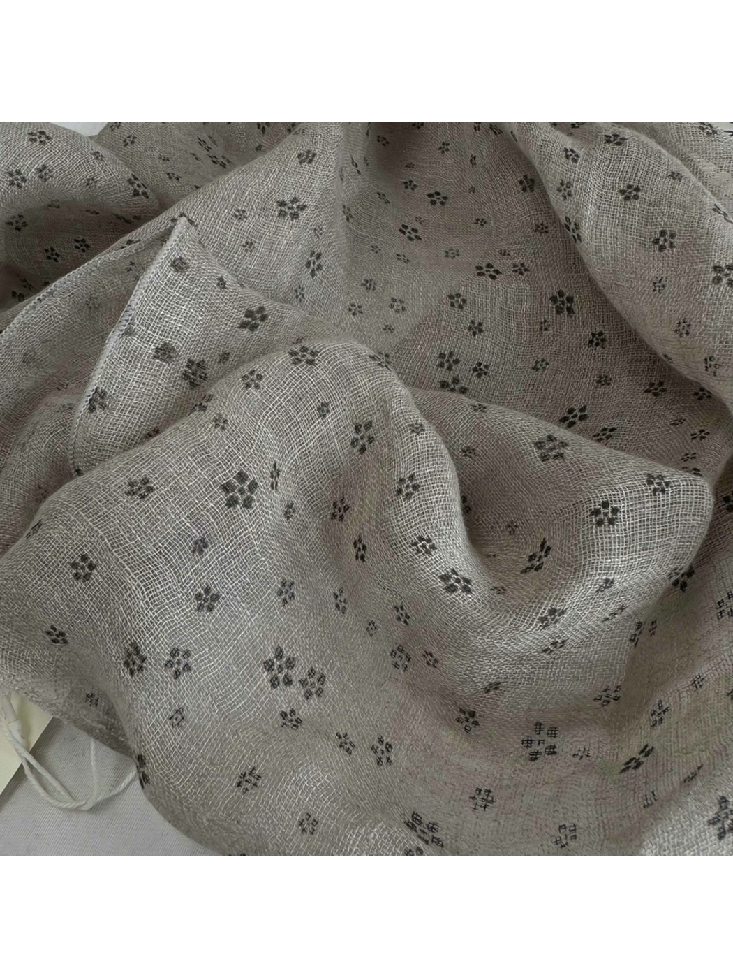 Close-up of the greige floral pattern and open woven texture