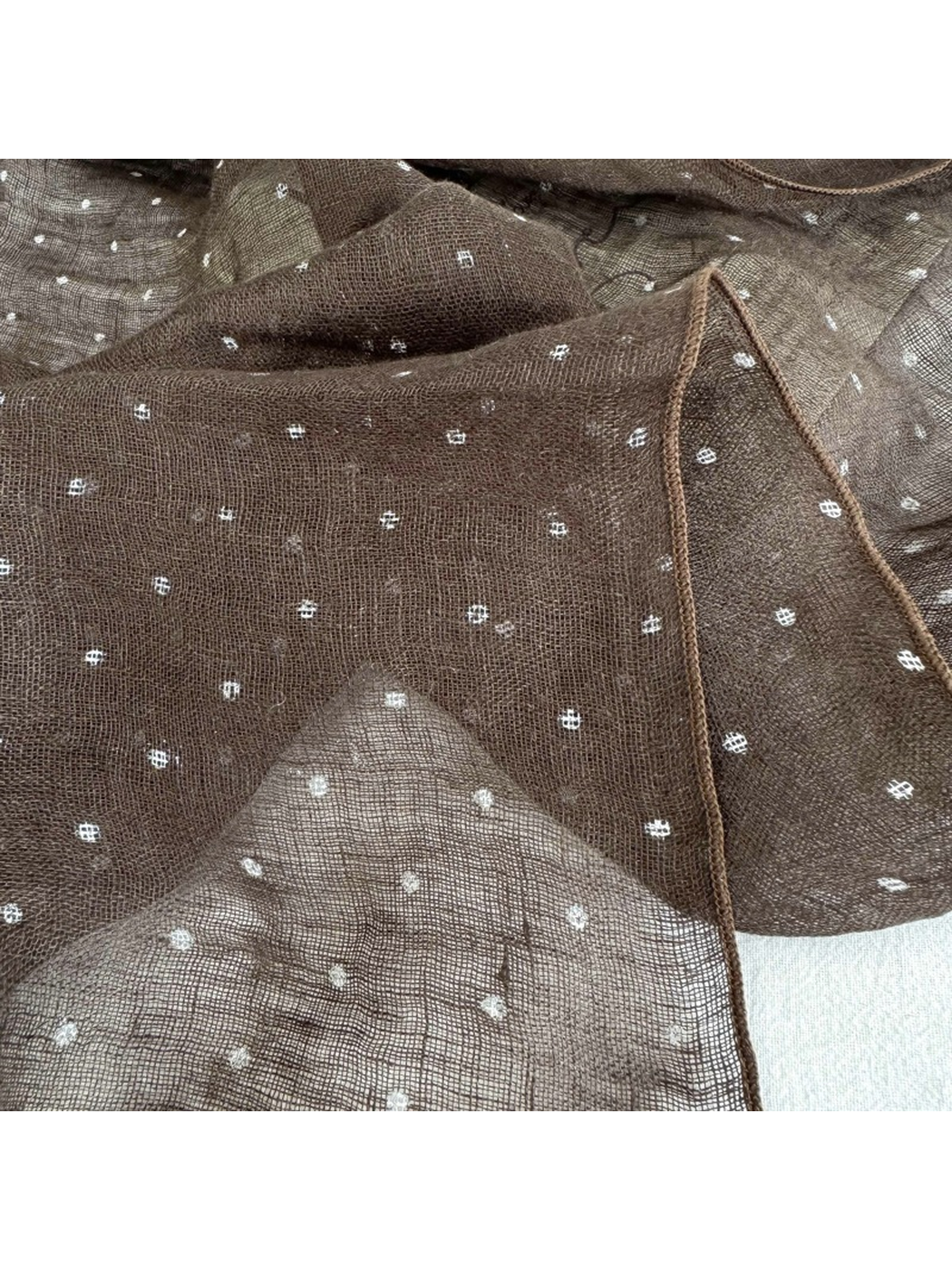 Close-up of the brown dotted pattern and stitched edge