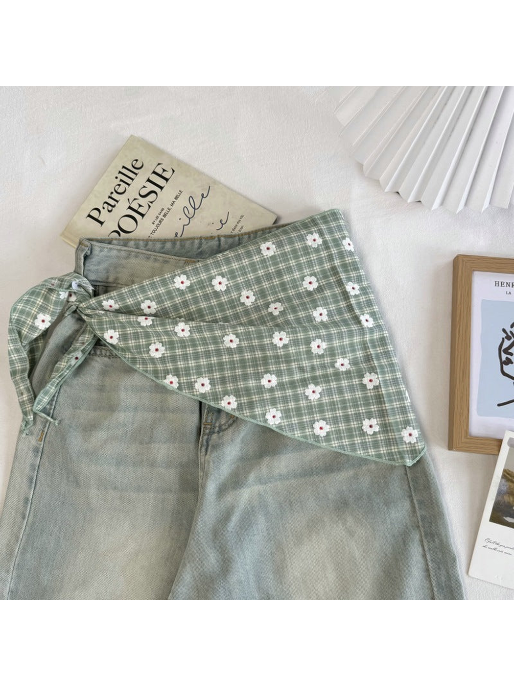 Green plaid scarf tied around the waist of pale green jeans