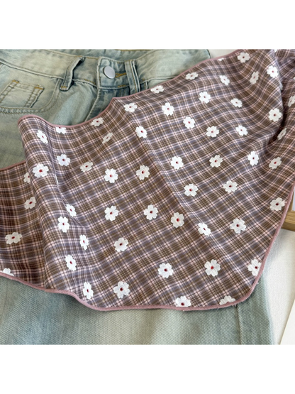 Close-up of the Dusty Pink plaid pattern, white daisy motifs and stitched edge