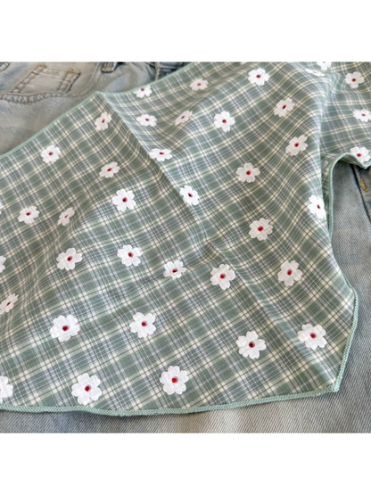 Close-up of the Green plaid pattern, white daisy motifs and stitched edge