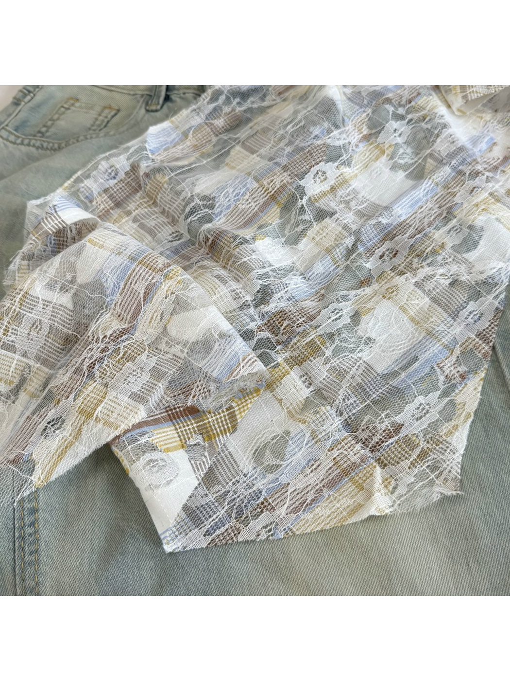 Close-up of Blue plaid, floral lace and frayed cutout details
